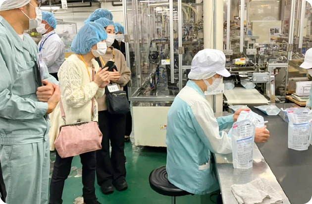 工場で製造工程を見学するマタニティアドバイザーの2人